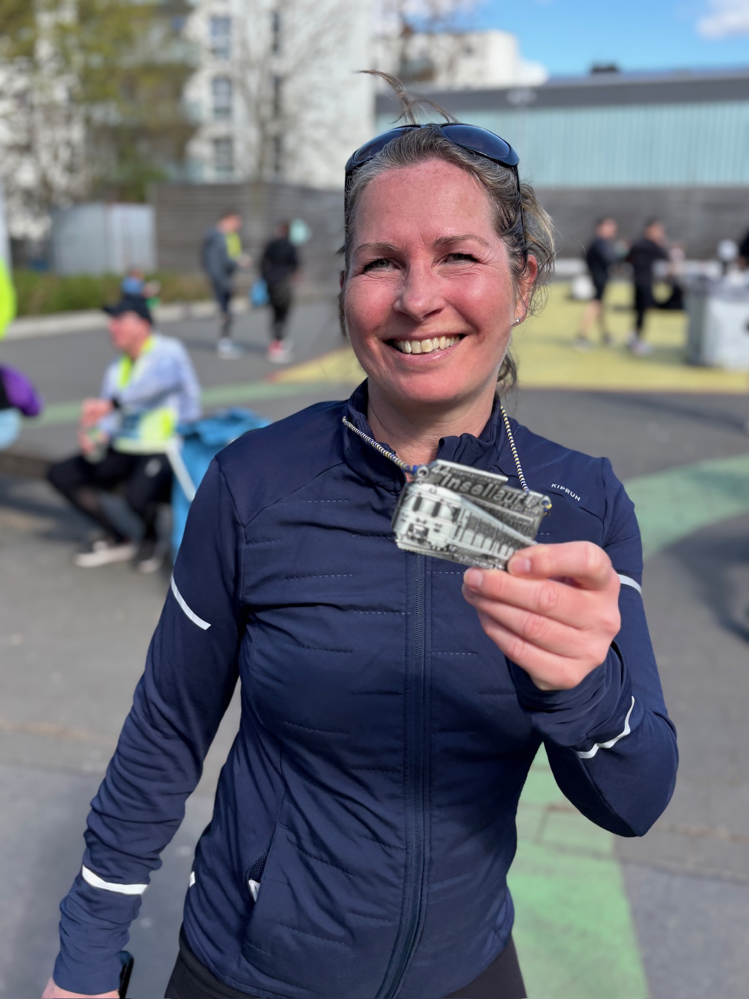 Kristin zeigt stolz ihre Laufmedaille